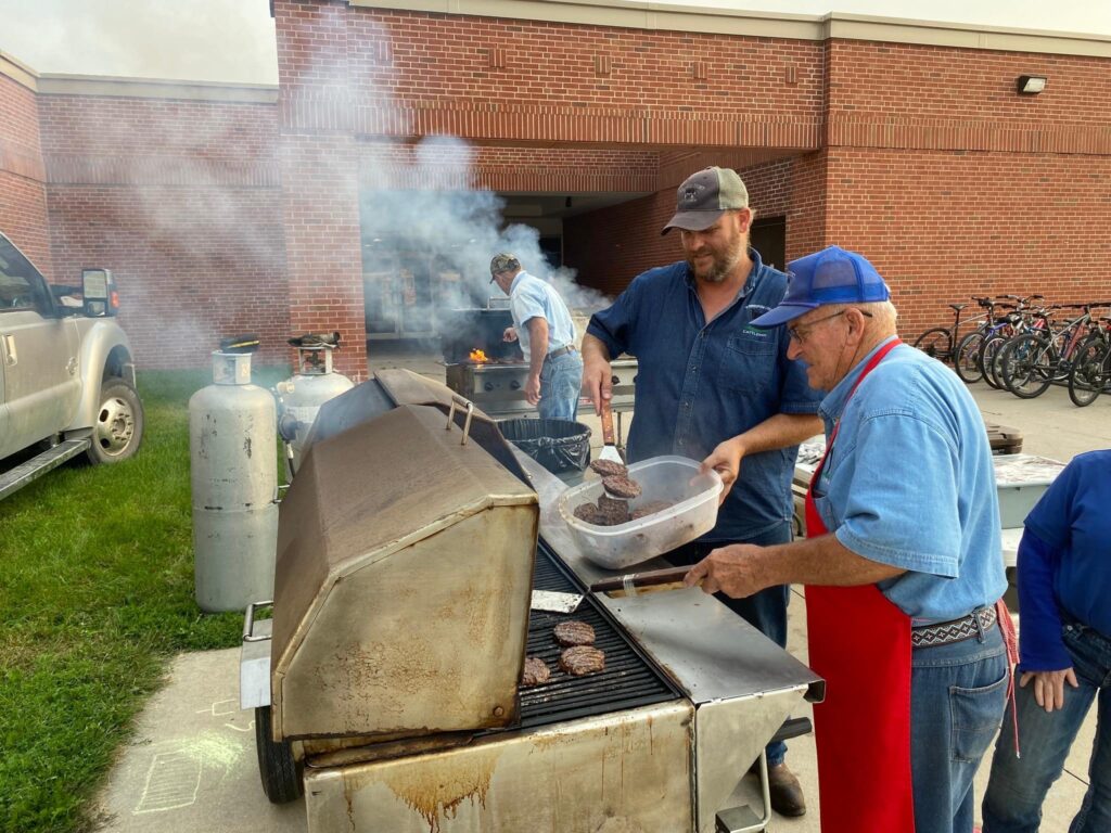 Beef producers grilling burgers at the high school