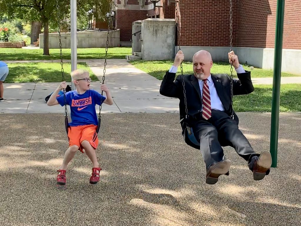 Superintendent Lane and son swinging